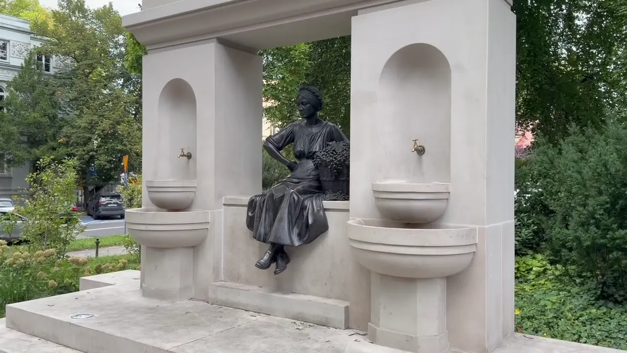 Seated bronze winemaker figure between two fountain basins
